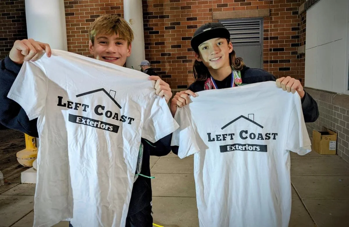 Two young athletes proudly holding Left Coast Exteriors sponsored jerseys and smiling